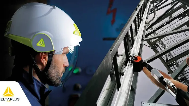 Worker wearing a Delta Plus safety helmet with a face shield, alongside work-at-height access equipment.