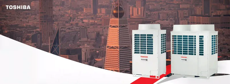 Toshiba VRF outdoor units on a city rooftop at dusk.